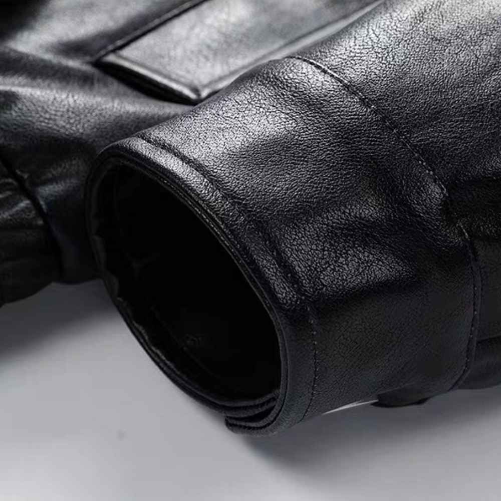 Close-up of black faux leather jacket cuff showing texture, stitching and edge finish