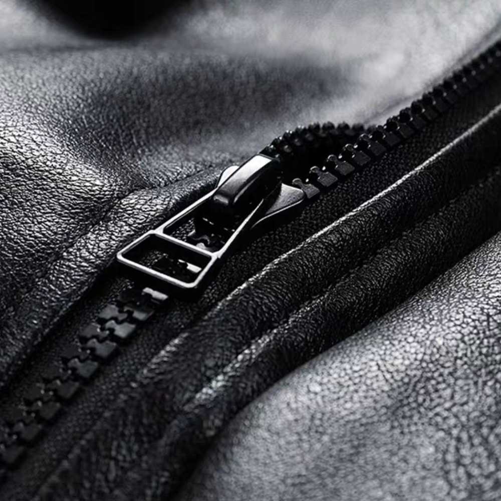 Close-up of the zipper on the black PU leather jacket showing textured material and smooth stitching