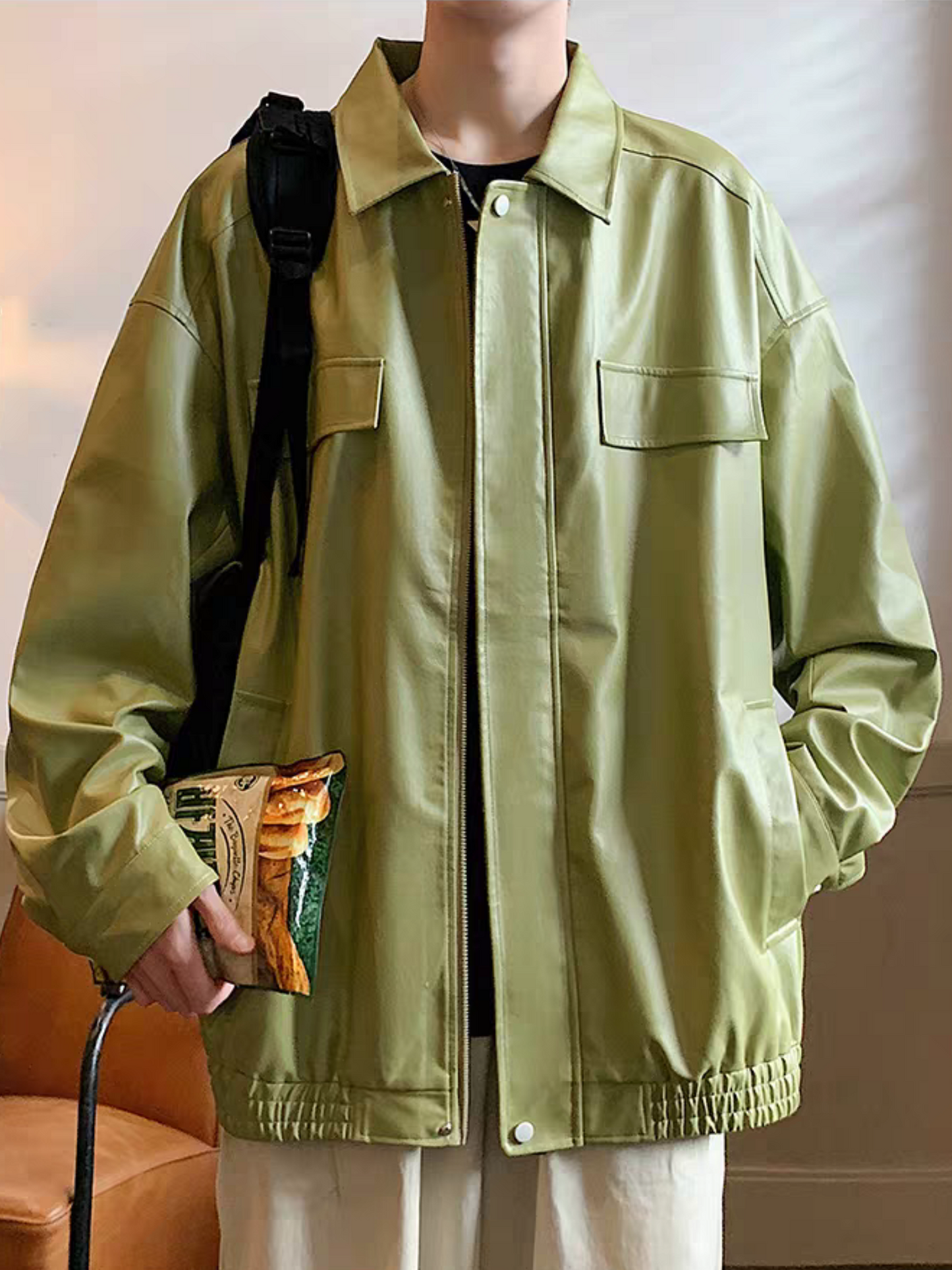 Asian male model wearing olive green PU leather jacket from STVLE, front view with chest pockets and standing collar - minimalist indoor streetwear look
