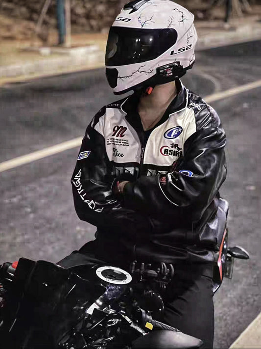 Biker wearing black Pop Trend PU leather racing jacket and helmet, sitting on motorcycle at night