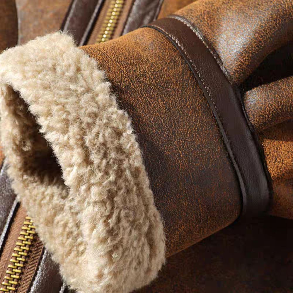 Close-up of faux shearling cuff with leather trim on brown aviator jacket, showing soft lining and vintage finish