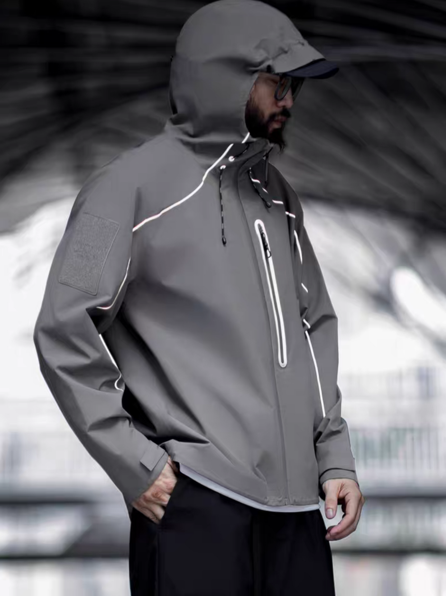 Side profile of model wearing STVLE lightsaber reflective tech jacket under a
futuristic urban overpass - sharp lines, muted tones, and functional edge