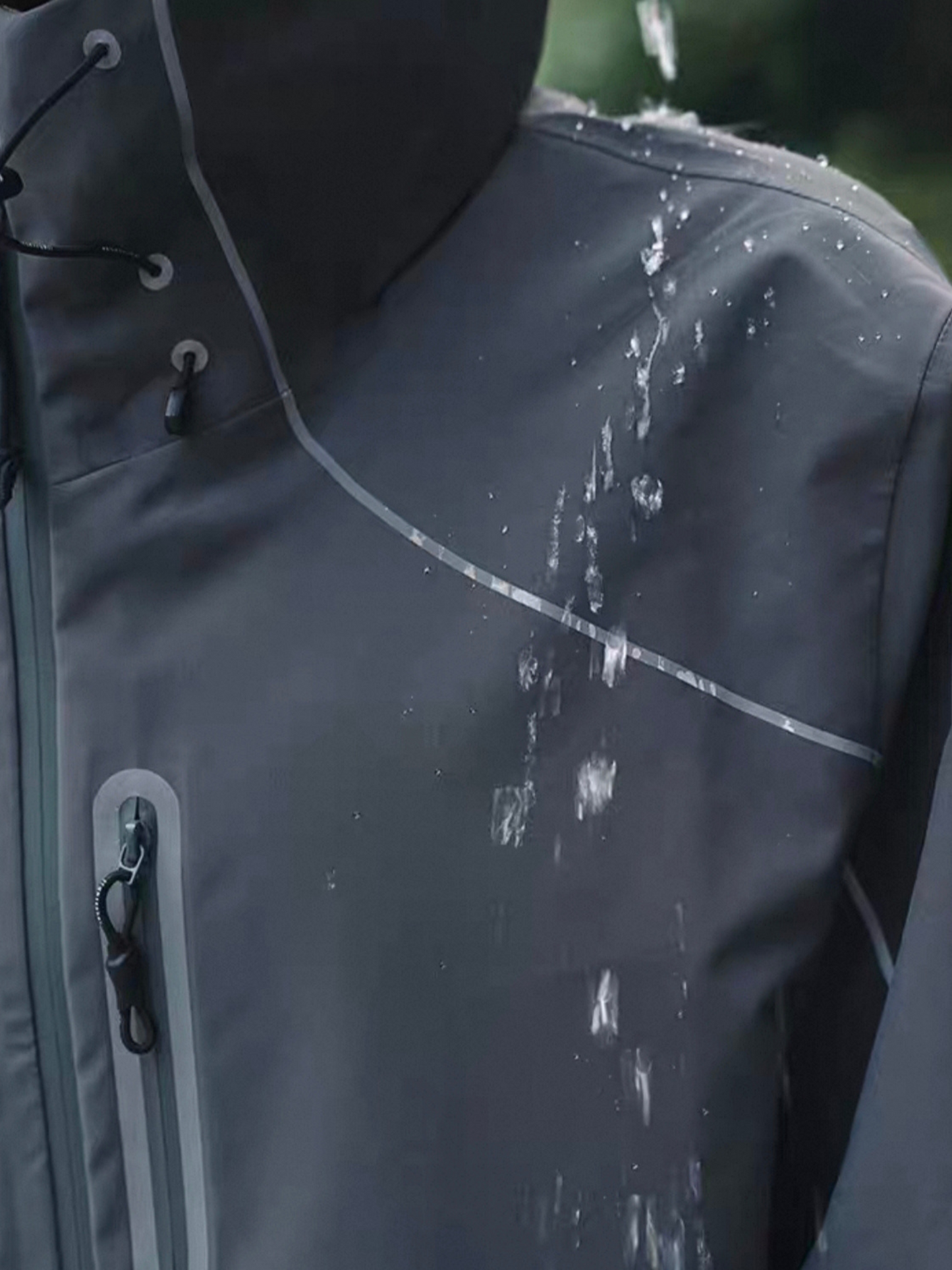 Close-up of STVLE lightsaber techwear jacket demonstrating water resistance, with water splashing and sliding off the fabric during waterproof test