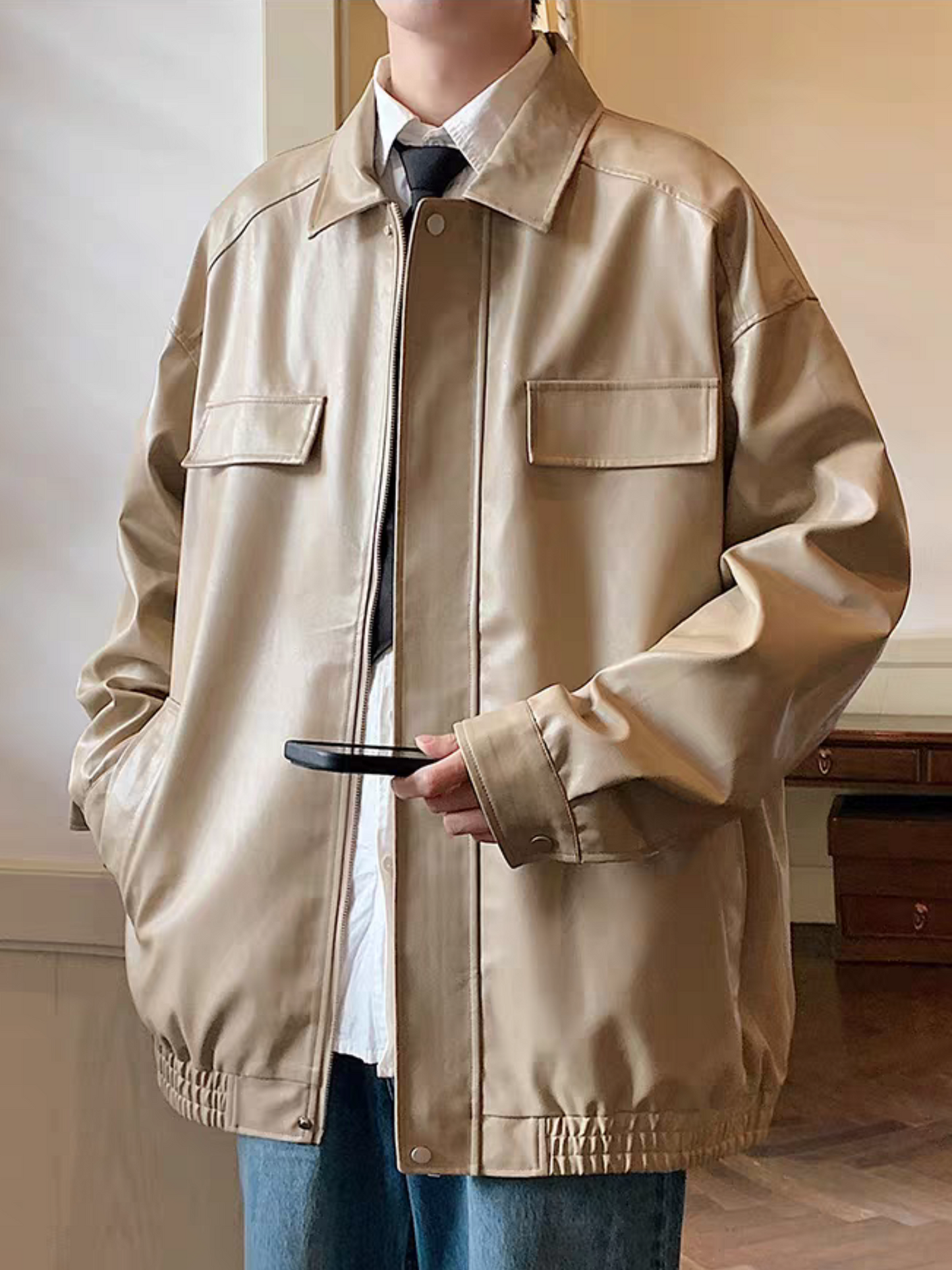 Asian male model wearing khaki PU leather jacket from STVLE, front view with chest flap pockets and turn-down collar, styled with shirt and black tie- casual smart look