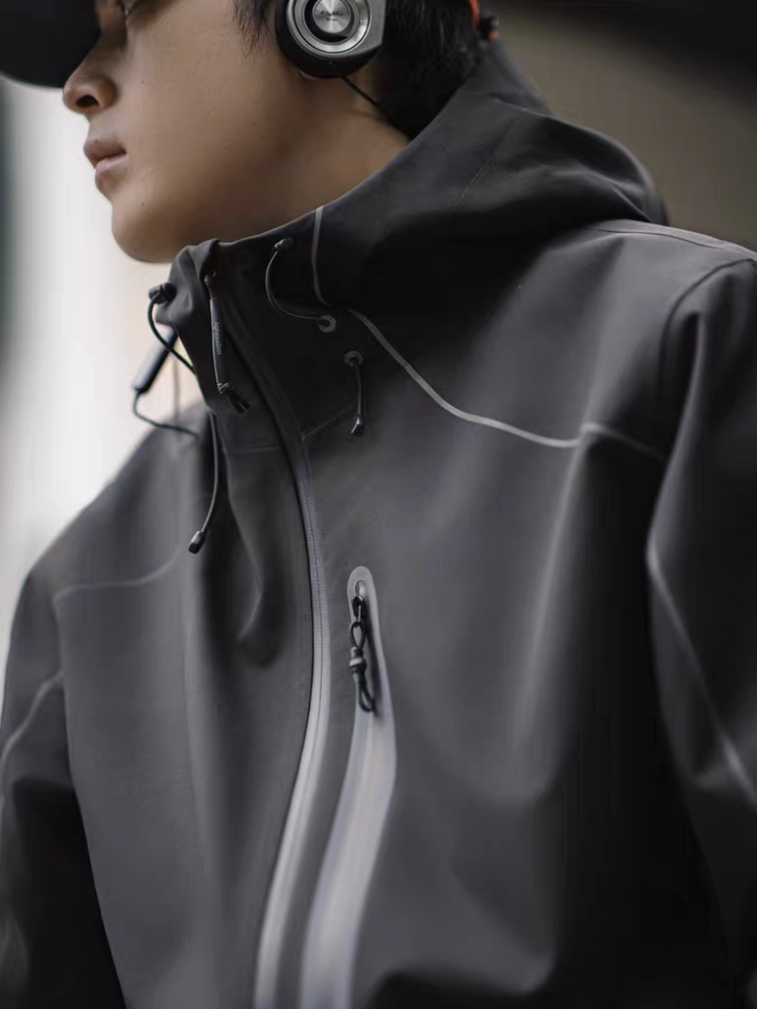 Side view of model wearing STVLE lightsaber reflective tech jacket, showing zipper and hood details