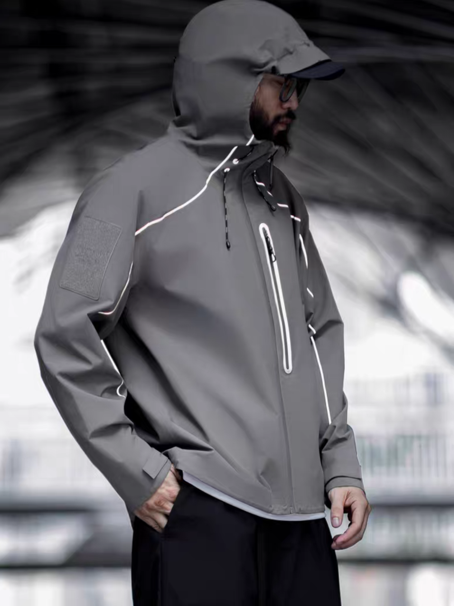 Side profile of model wearing STVLE lightsaber reflective tech jacket under a    
futuristic urban overpass - sharp lines, muted tones, and functional edge        